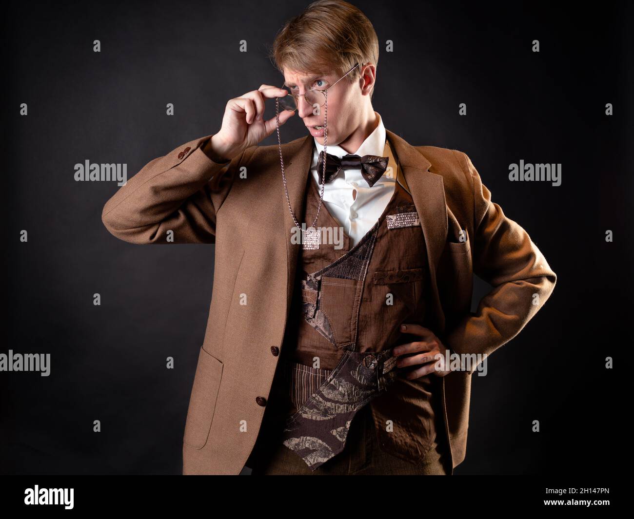 An intelligent gentleman in the Victorian style. Vintage retro suit, young attractive man in a vest and bow tie Stock Photo