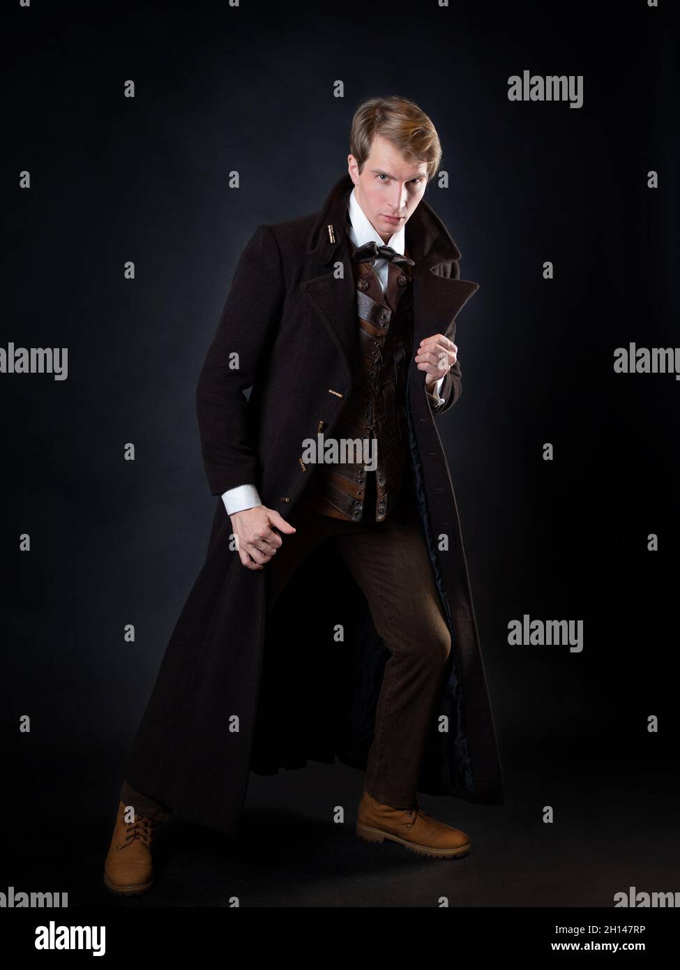 the character of the steampunk story, a young attractive man in an elegant long coat. intelligent gentleman in the Victorian style. Vintage retro suit Stock Photo