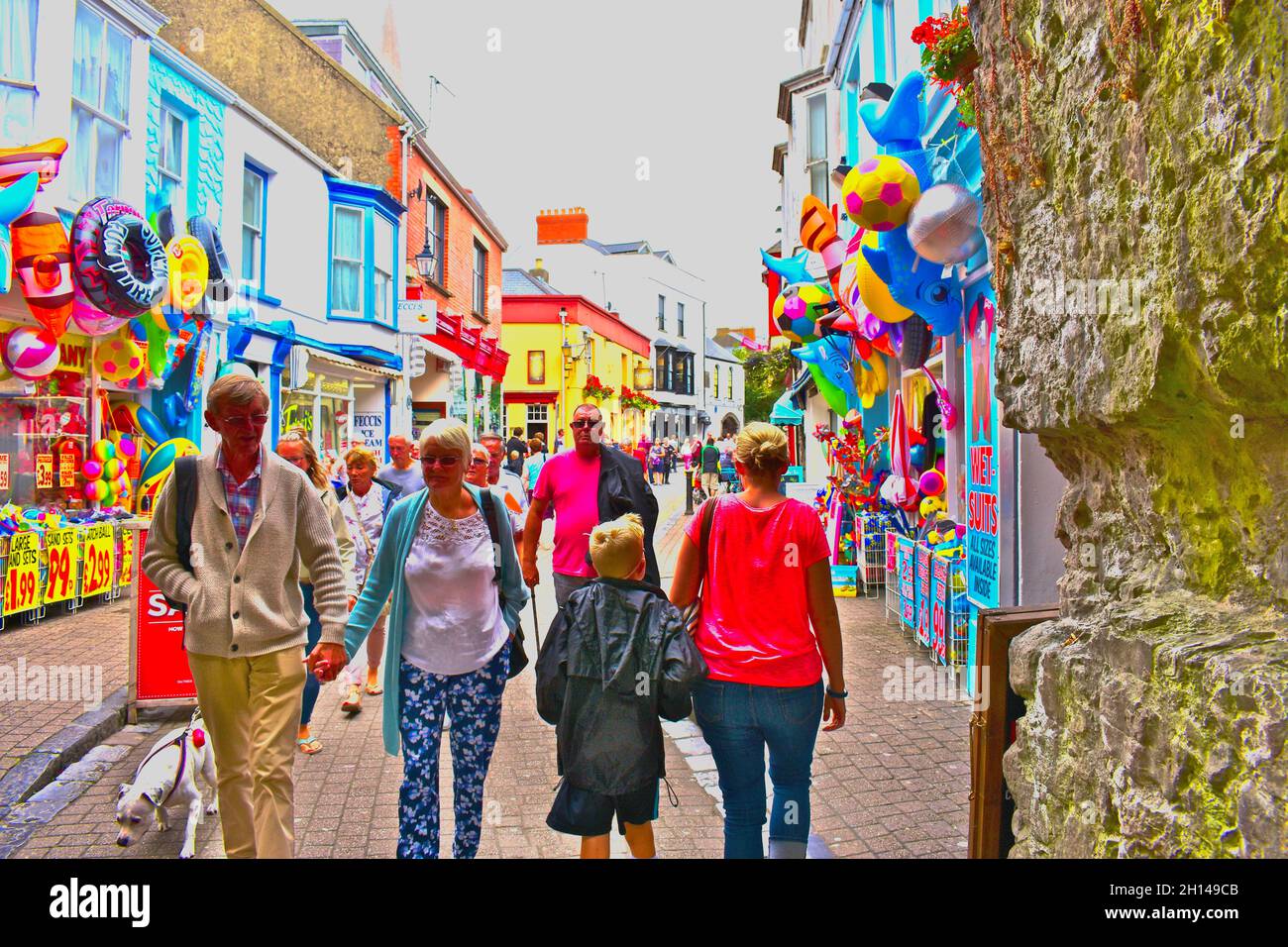 Holidaymakers stroll along St Street in Tenby, which is filled
