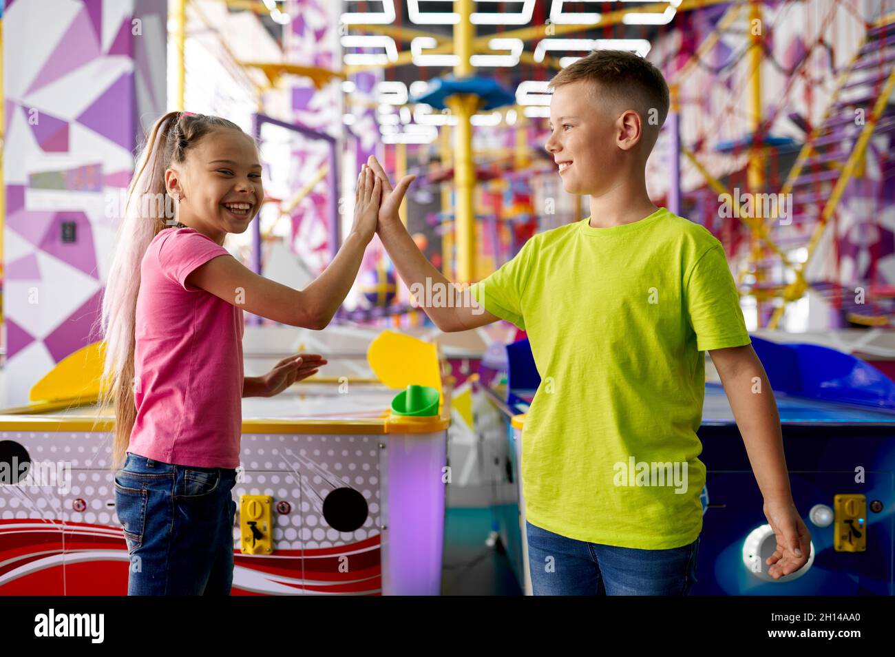 Little girl and boy play air hockey on playground Stock Photo Alamy