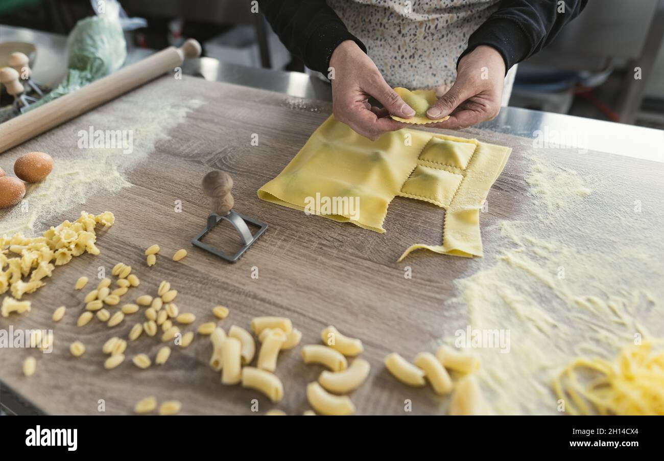 Close up female hands preparing fresh homemade ravioli pasta Stock Photo