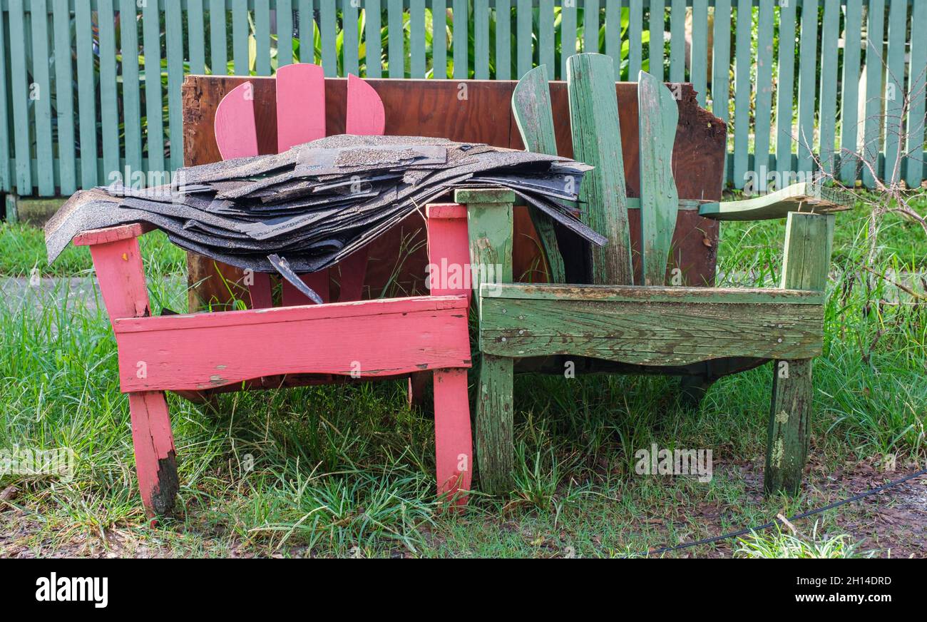 Stack of Roof Shingles on Two Wooden Chairs on the Curb for Trash Pickup Following Hurricane Stock Photo