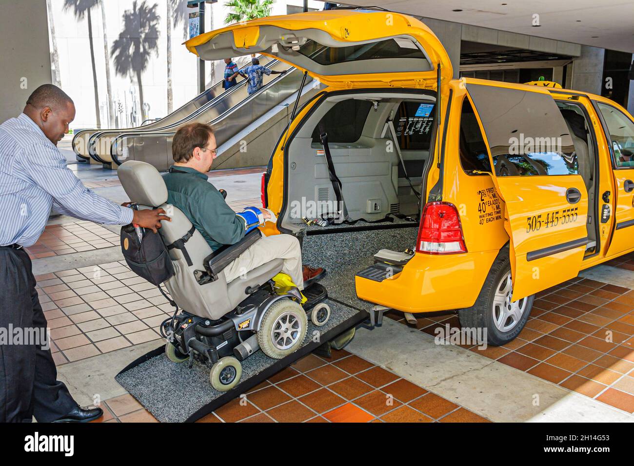 Miami Florida,Disability Resource Fair taxi cab,wheelchair ramp Black man men disabled handicapped male driver Stock Photo