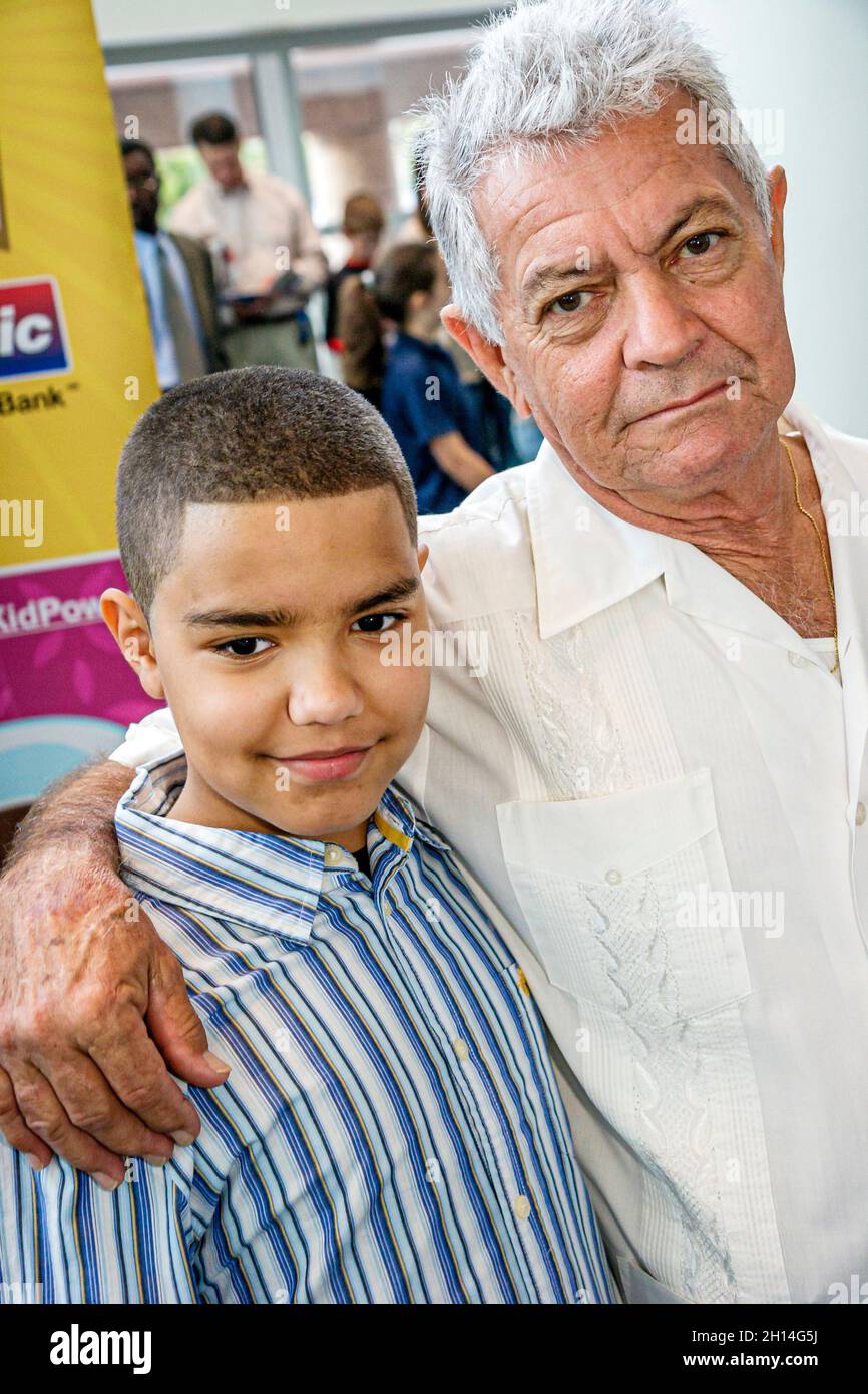 Miami Florida,Spelling Bee,contestant competitor participant student family,Hispanic boy male grandson grandfather senior citizen hugging Stock Photo