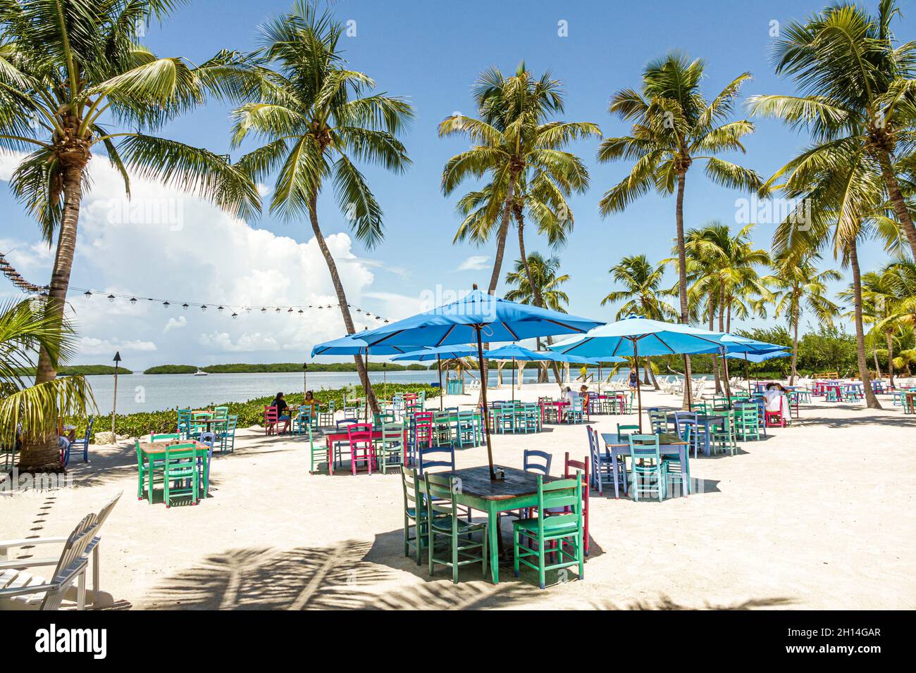 Islamorada Upper Florida Keys,Pierre's Beach Cafe & Bar Morada Bay restaurant,al fresco outside tables dining waterfront umbrellas palm trees Stock Photo