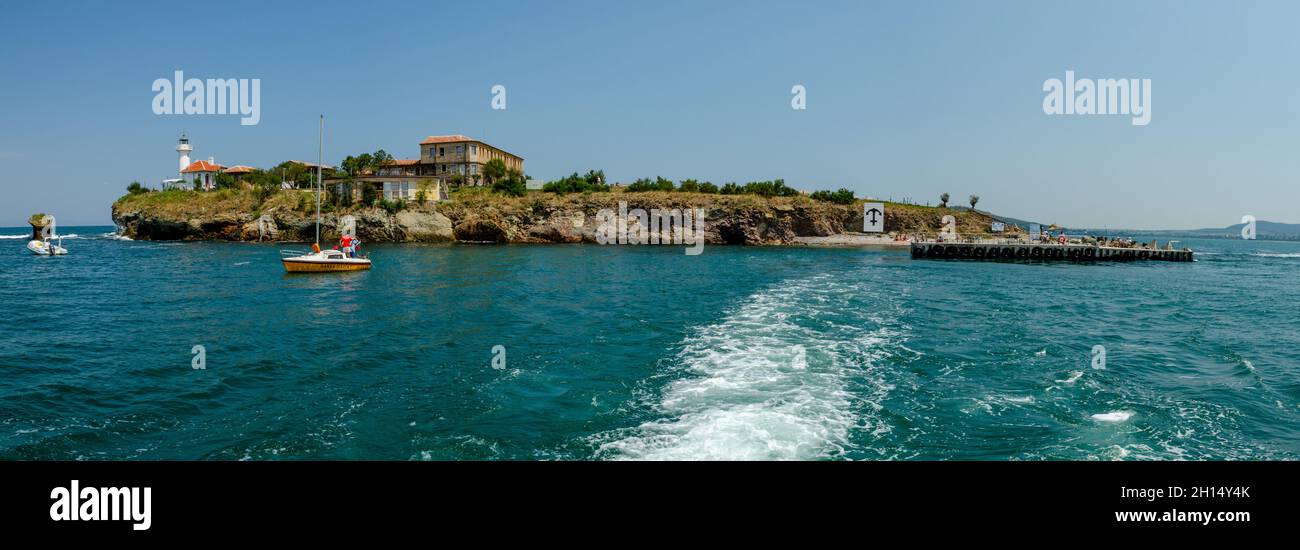 Saint Anastasia Island in Burgas bay, Black Sea, Bulgaria. Lighthouse tower and old wooden buildings on rocky coast. Stock Photo