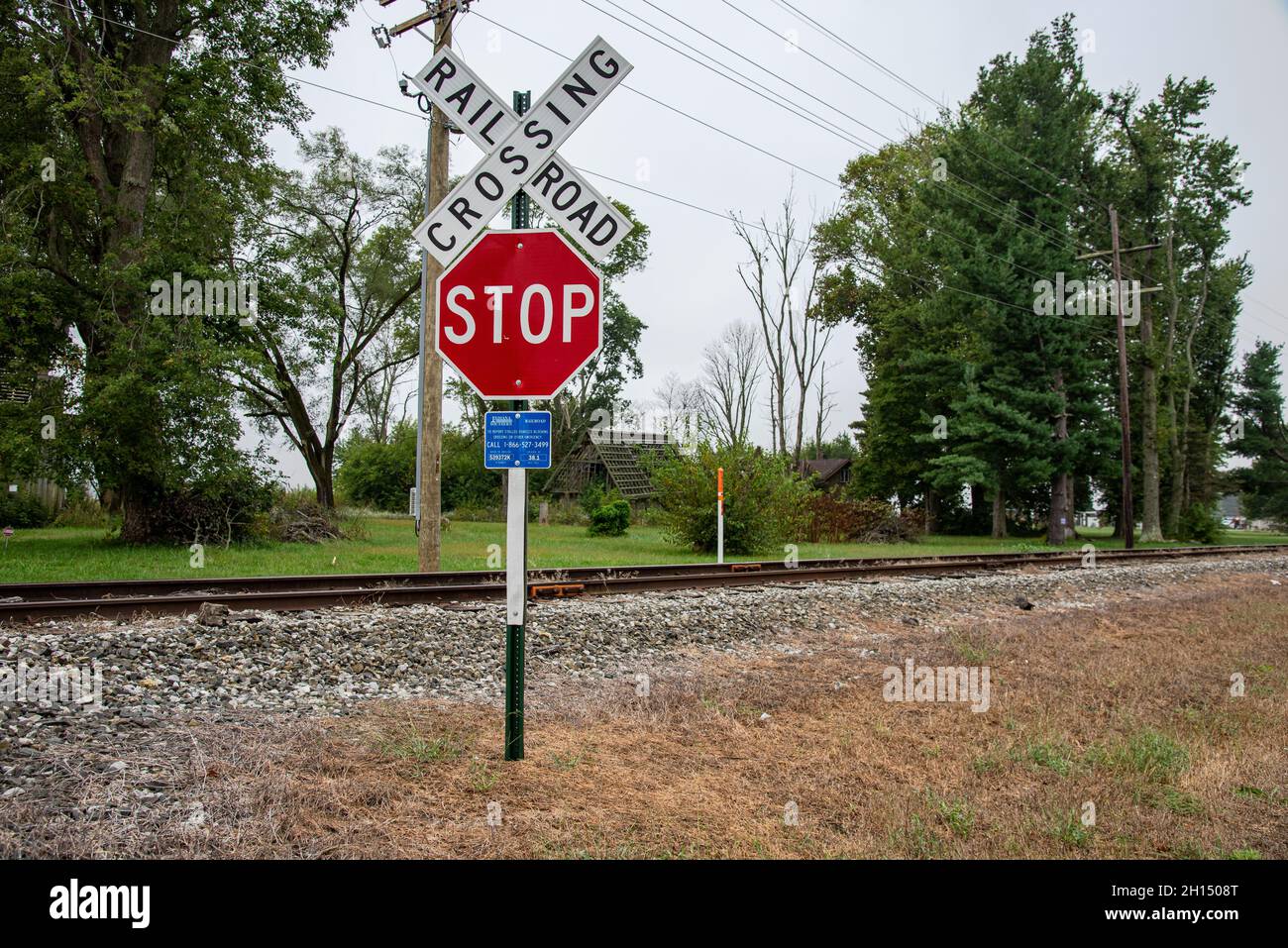 A stop sign and railroad crossing sign next to the railroad tracks with
