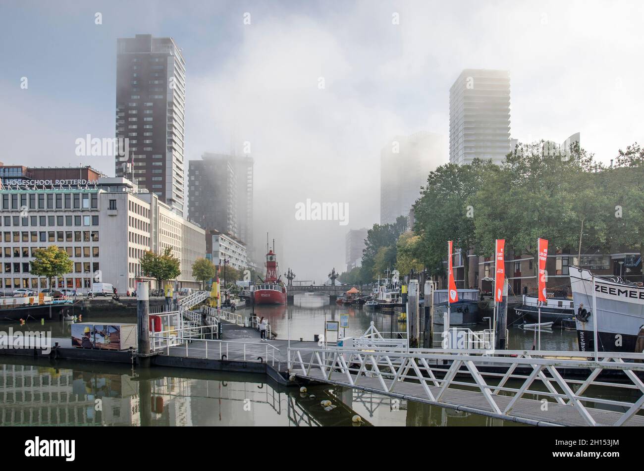 Rotterdam, The Netherlands, October 8, 2021: shards of fog moving away as the sun breaks through over Wijnhaven harbour Stock Photo