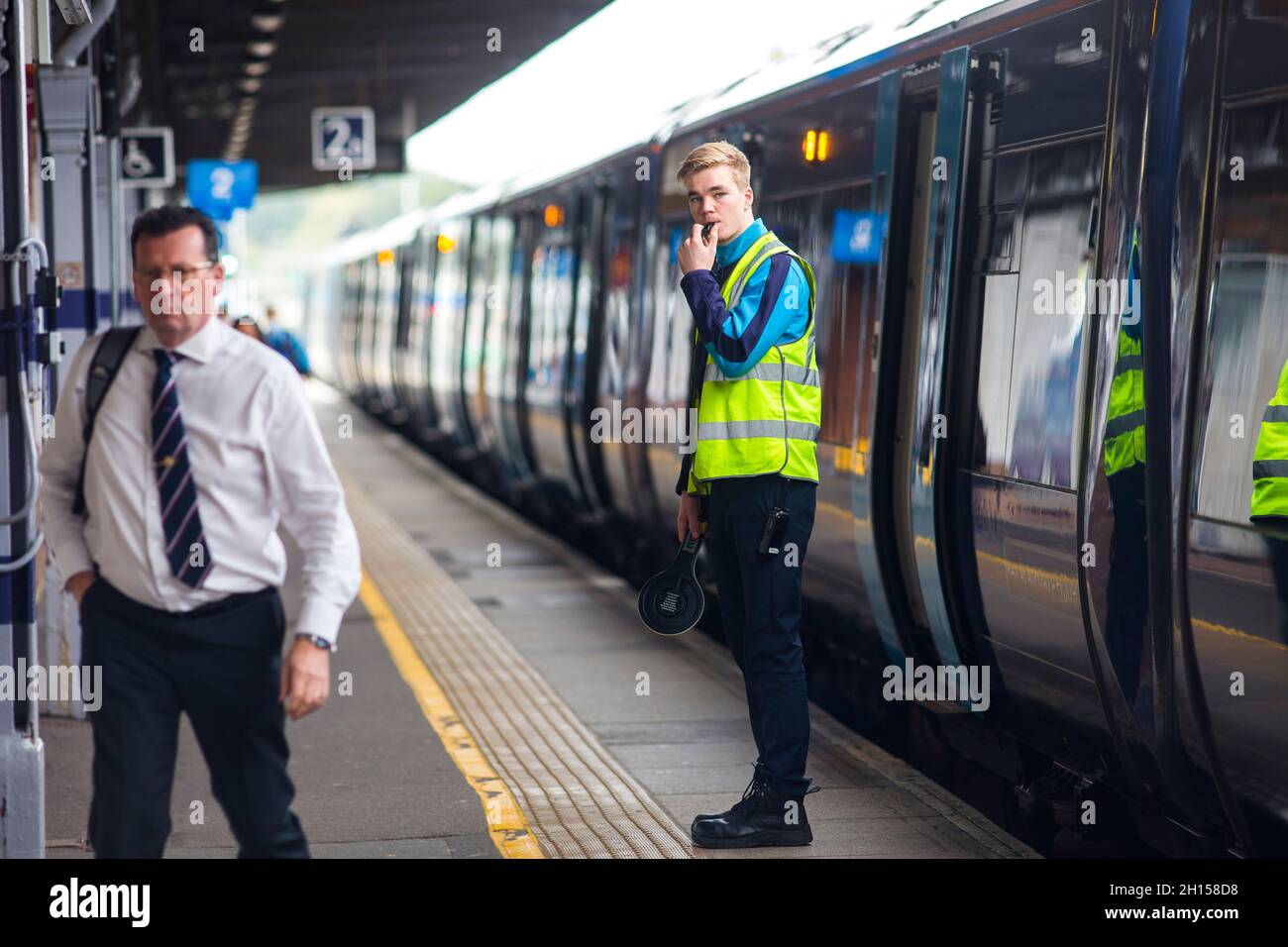 A Southeastern railways employee prepares to dispatch a train at Tonbridge railways station in