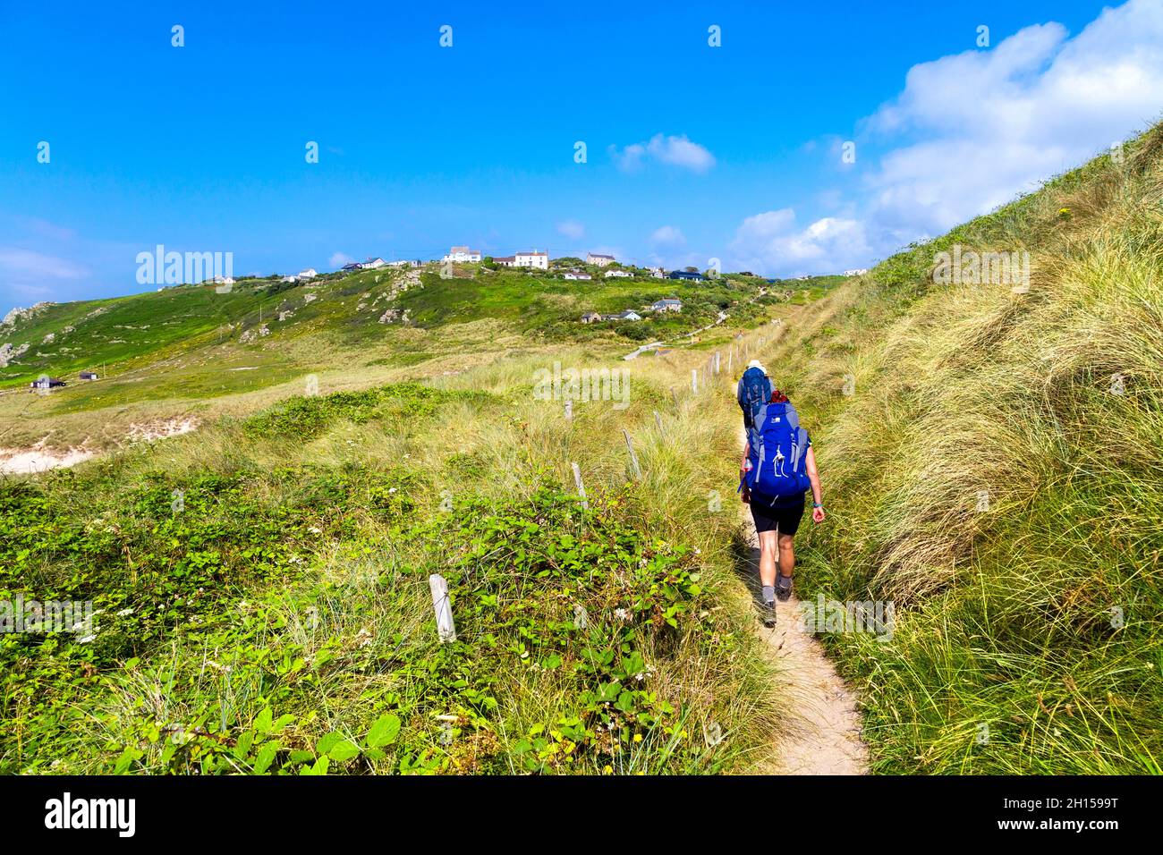 Hikers walking along the South West Coast Path near Gwynver Beach, Sennen, Coranwall, UK Stock Photo