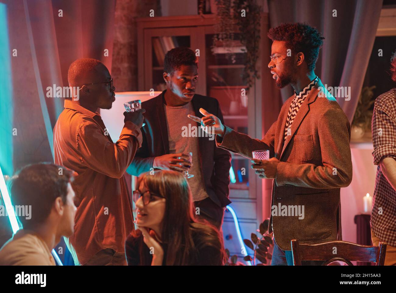 African young men having a meeting at social event they talking to each other and drinking alcohol Stock Photo