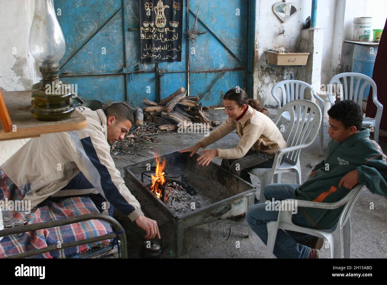 Atef Sukar, 24, and his younger brother and sister make tea at their Gaza City home. Sukar is a supporter of Fatah which now has no control in Gaza after Hamas staged a coup taking effective control of the Gaza Strip. Palestine. Dec. 29, 2005. Stock Photo