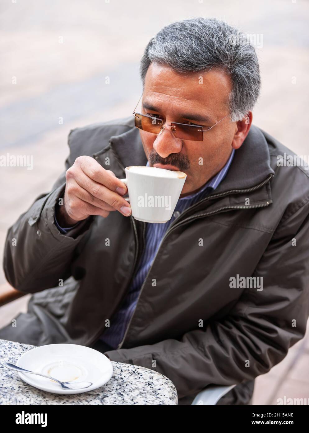 Portrait of an Iranian Arabic business man sipping cappuccino  in a shopping center Stock Photo