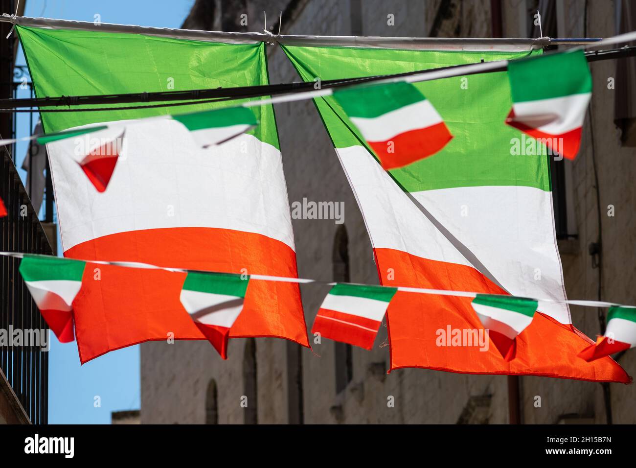Italian flags and pennants in an old town narrow street of a city in Italy Stock Photo