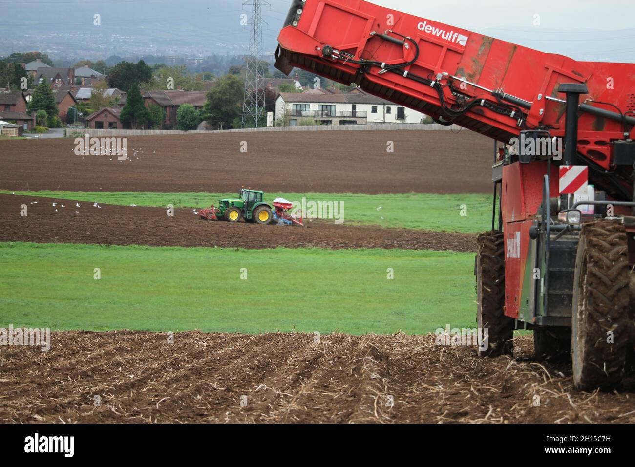 John Deere tractor and Kverneland Seed Drill viewed past a Dewulf