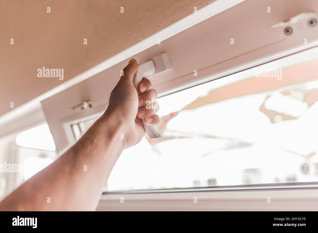 The guy's hand opens a plastic double window for the handle pvc double