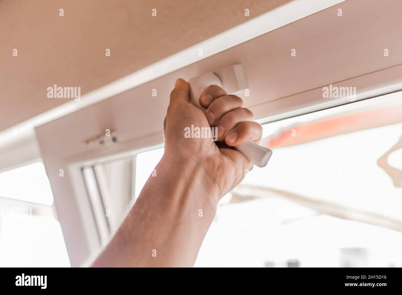 The guy's hand opens a plastic double window for the handle pvc double