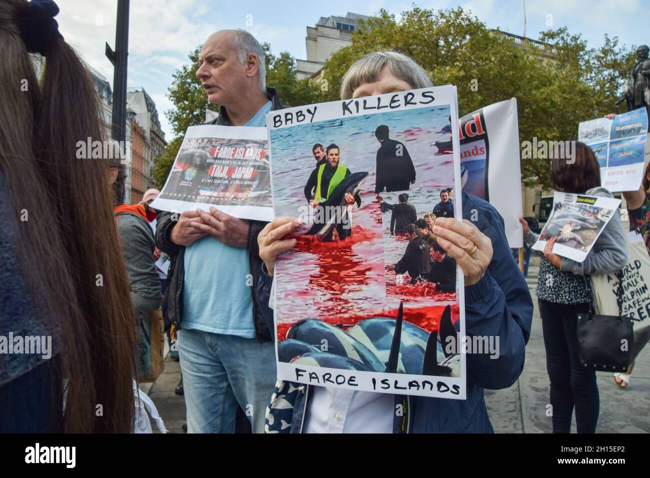 London, UK. 16th Oct, 2021. A protester holds a placard with a graphic image of dolphin killing in Faroe Islands during the demonstration in Trafalgar Square.Members of marine conservation organization Sea Shepherd and other activists marched through Westminster, calling for an end to the slaughter of dolphins in Faroe Islands and Taiji, Japan. Credit: SOPA Images Limited/Alamy Live News Stock Photo