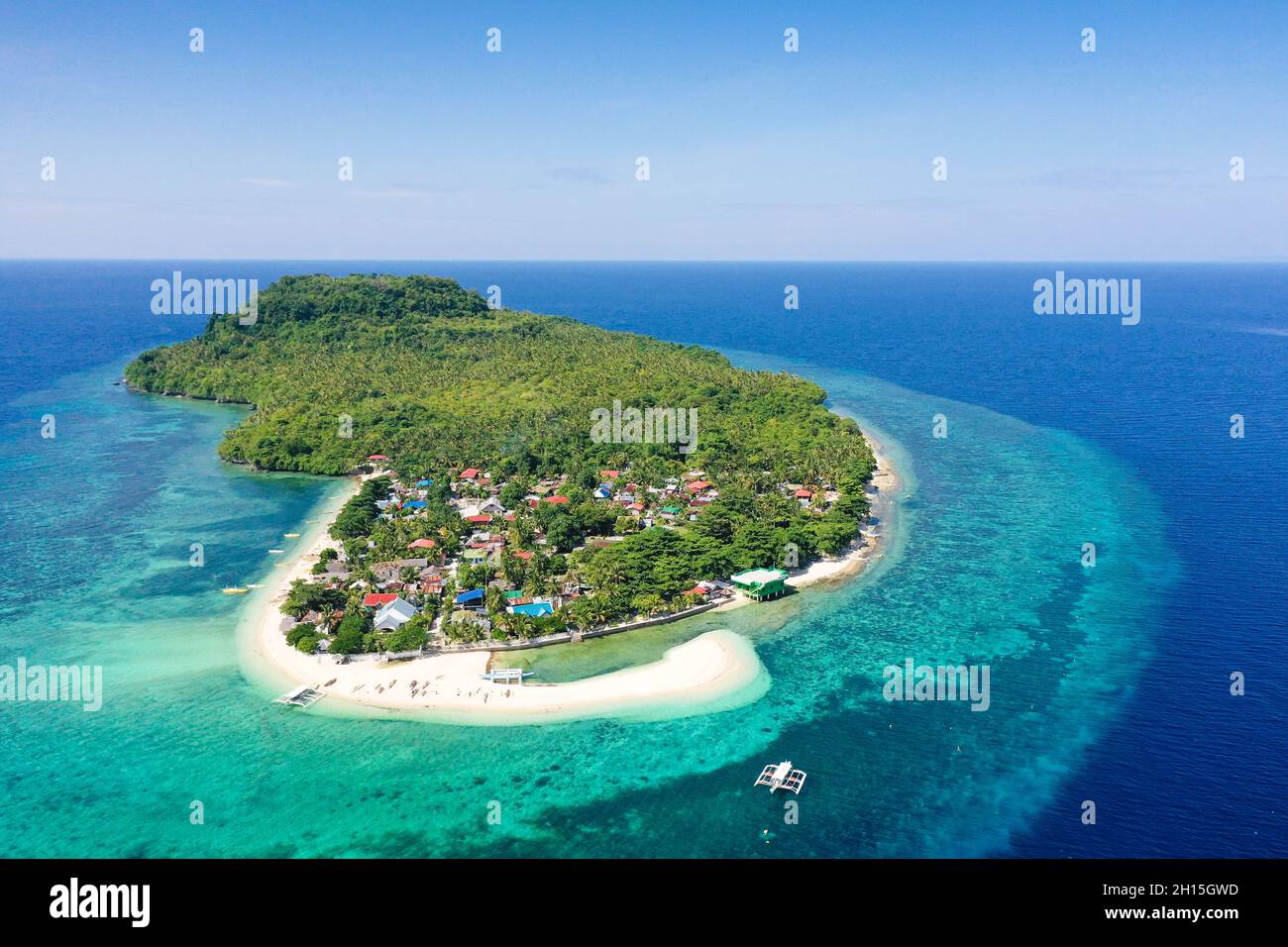 Himokilan Island, Leyte Island, Philippines. Tropical island with a village and a white beach. Turquoise water and coral reefs around the island. Summ Stock Photo