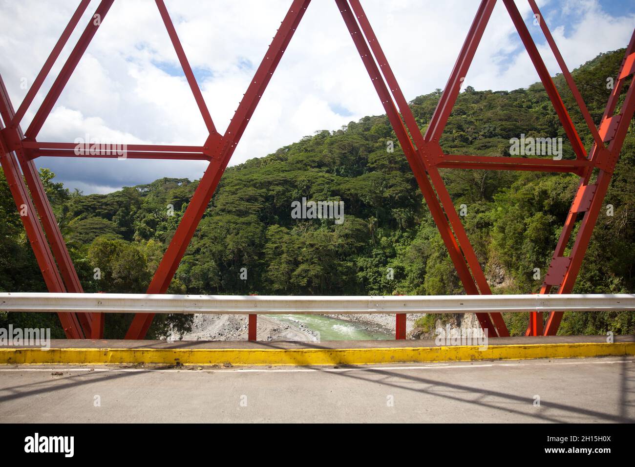 Steel structure bridge close-up. Concrete road and bridge with red beams. Stock Photo