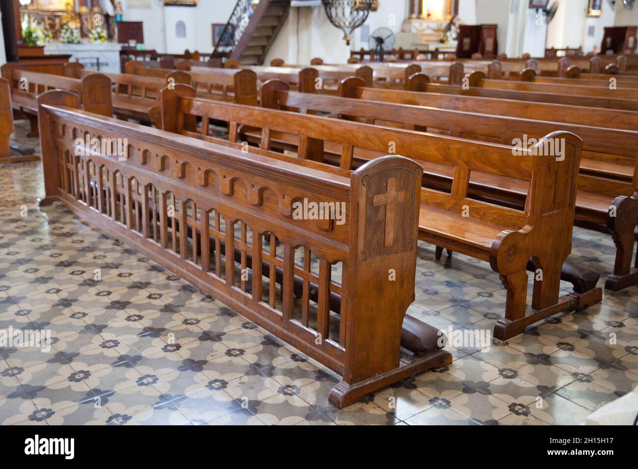 Bench in the catholic church. old wooden benches in the cathedral. The interior of the Philippine church. Stock Photo