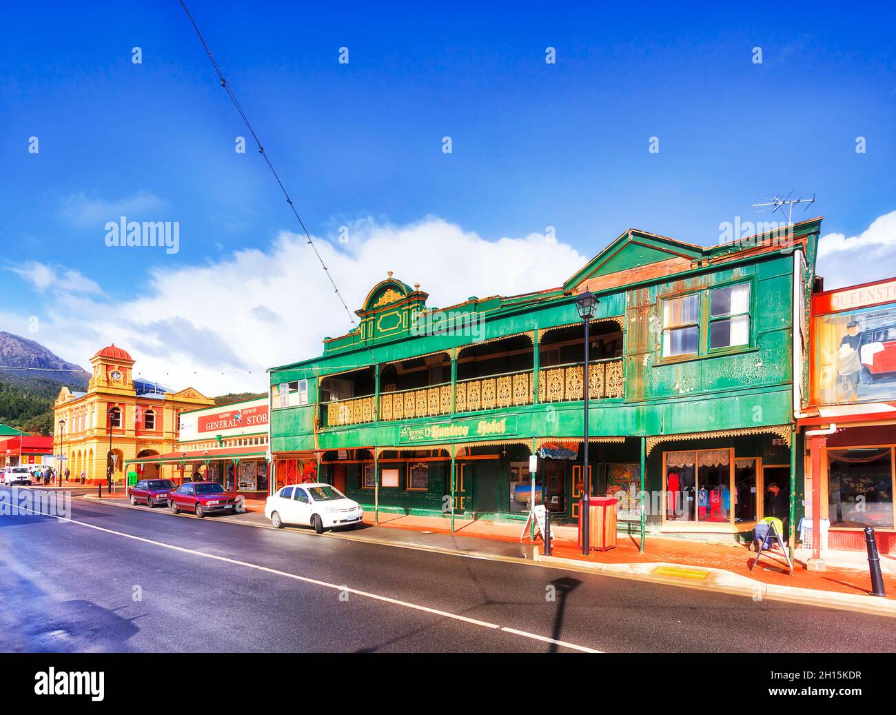 Queenstown, Australia - 24 April 2014: Main shopping street with general stores and historic heritage hotel under blue sky. Stock Photo
