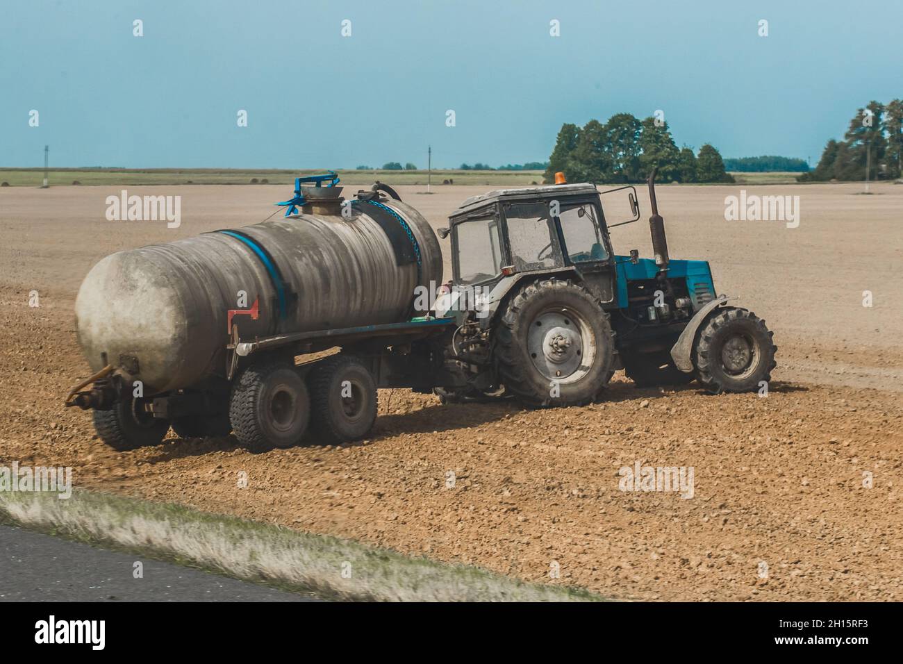 Tractor with a barrel of fertilizer in the field. Agricultural