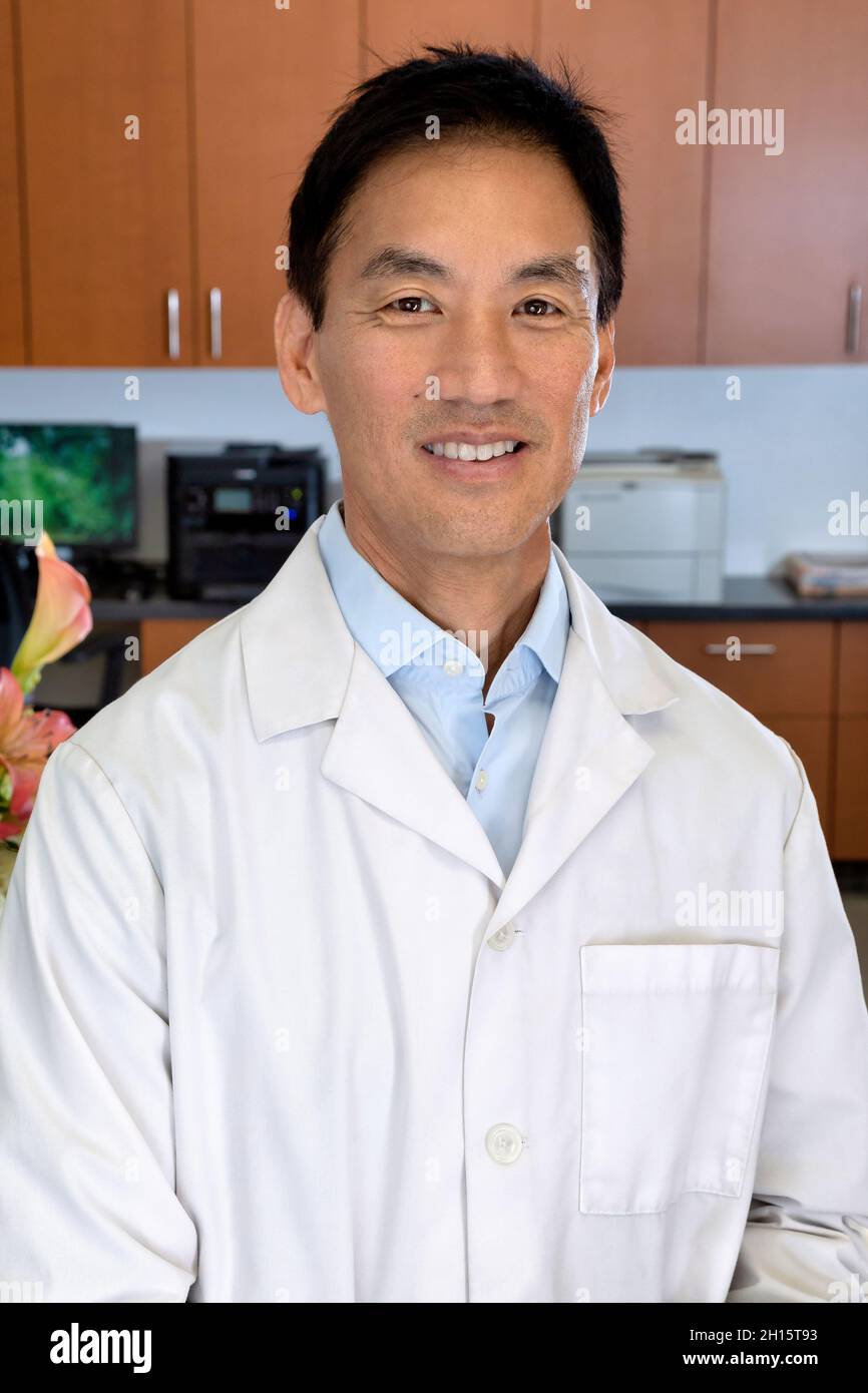 Asian male doctor in his front desk office Stock Photo Alamy