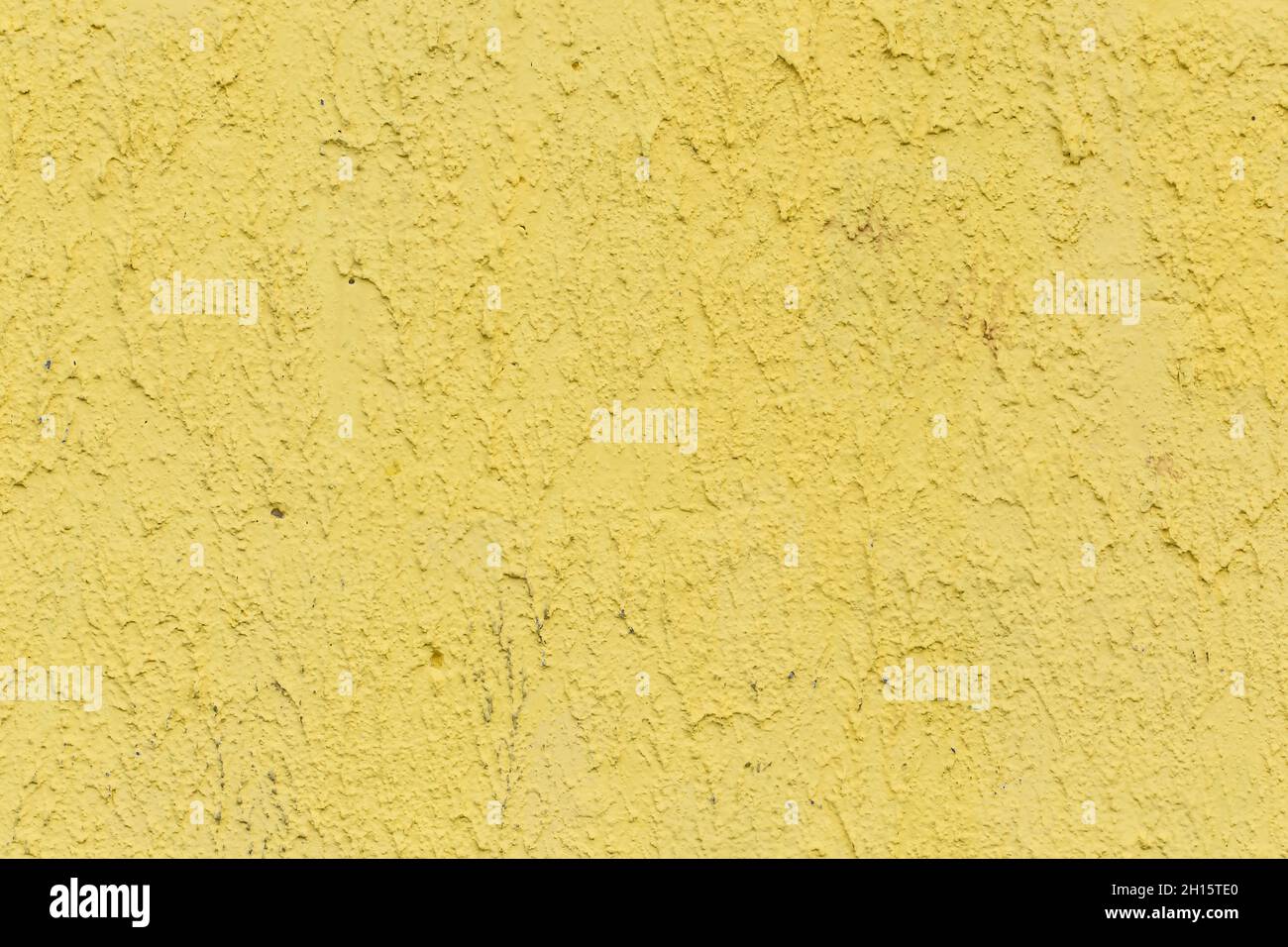 Yellow paint on old rough abstract wall texture background Stock Photo