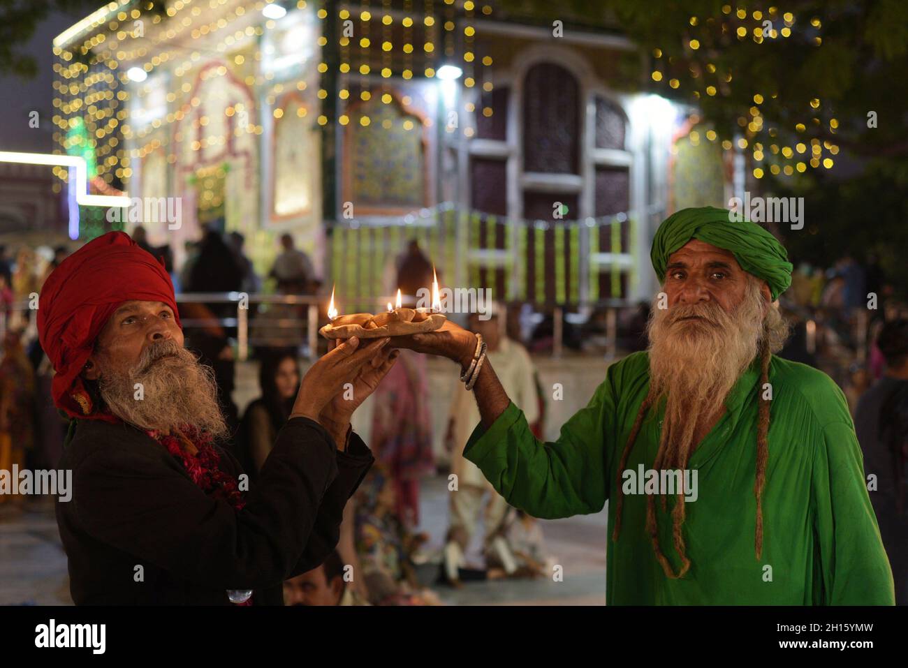 Pakistani Muslim devotees take part in the 398th birth anniversary Urs celebration second and last day at the shrine of Sufi saint Baba Sain Mir Mohammed Sahib popularly known as Hazrat Mian Mir Muhammad Bala Pir Shah Mir in Lahore on October 15, 2021. Devotees, including women and children visited the shrine, light earth lamps, Sufi devotees light earth lamps and performing dhammal on beat drum, offered Fateha and paid homage to the great saint. Two-day annual Urs of Sufi saint Hazrat Mian Mir is observed with respects and veneration every year. (Photo by Rana Sajid Hussain/Pacific Press/Sipa Stock Photo
