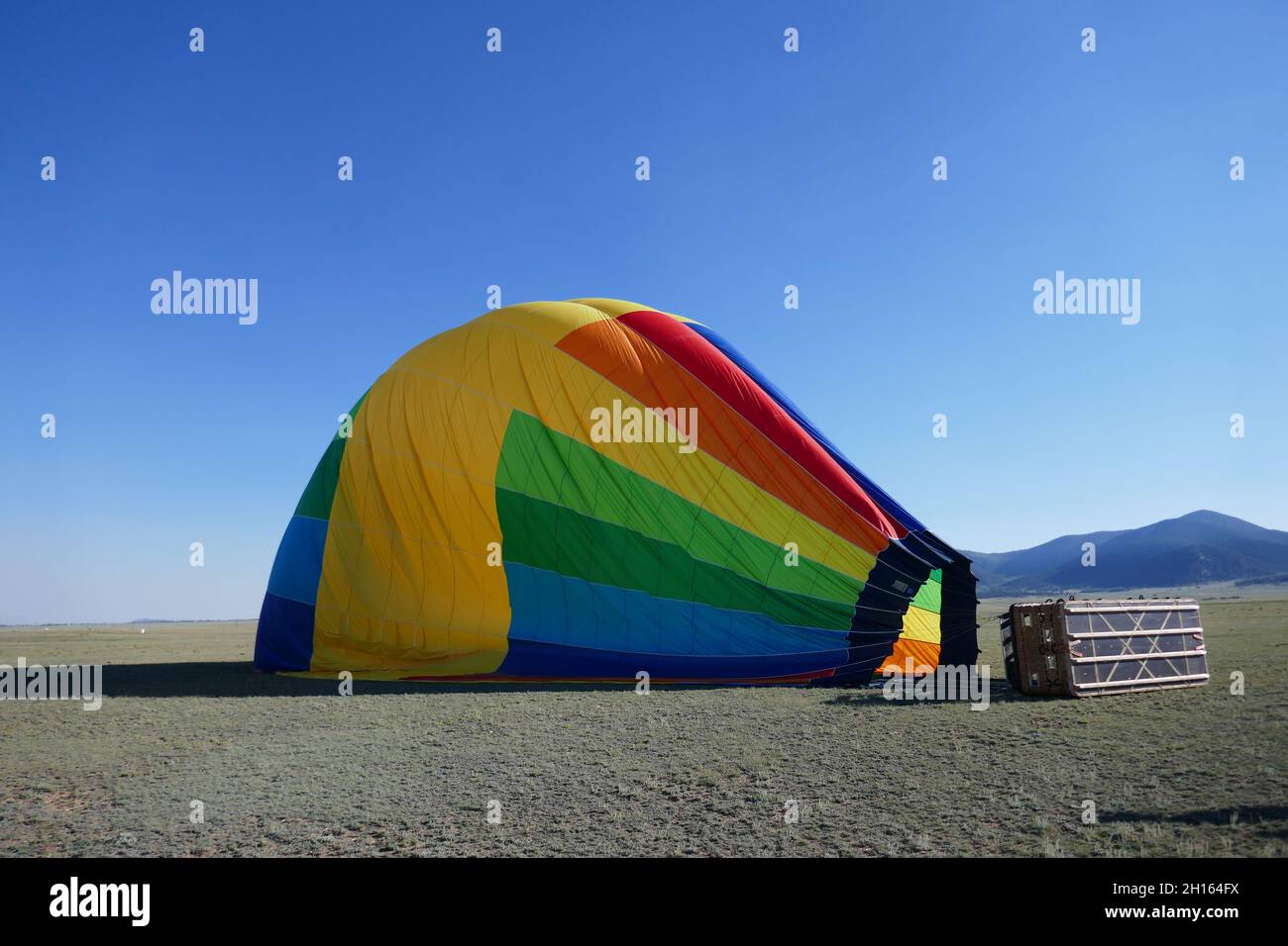 Deflated rainbow colored hot air balloon laying on side Stock Photo