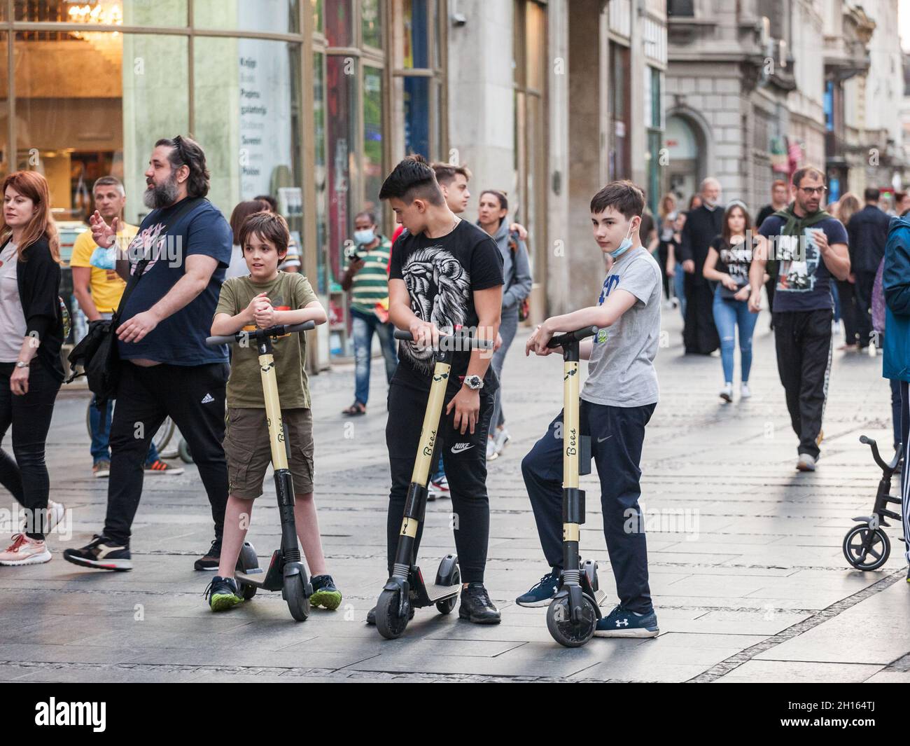 BELGRADE, SERBIA - MAY 27, 2021: group of youngsters, male boy kids, standing with an electric scooter in a street of Belgrade. Electric scooters are Stock Photo