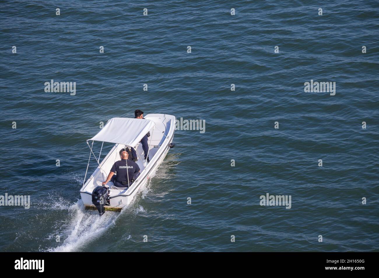 SREMSKA MITROVICA, SERBIA - AUGUST 8, 2021: Serbian border police officers in uniform patrolling on the Sava river on a boat, belonging  to the civili Stock Photo