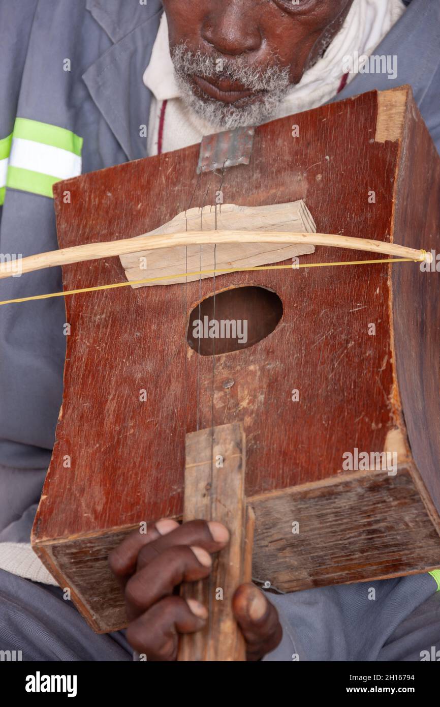 old man playing a traditional handmade violin in Botswana Africa Stock