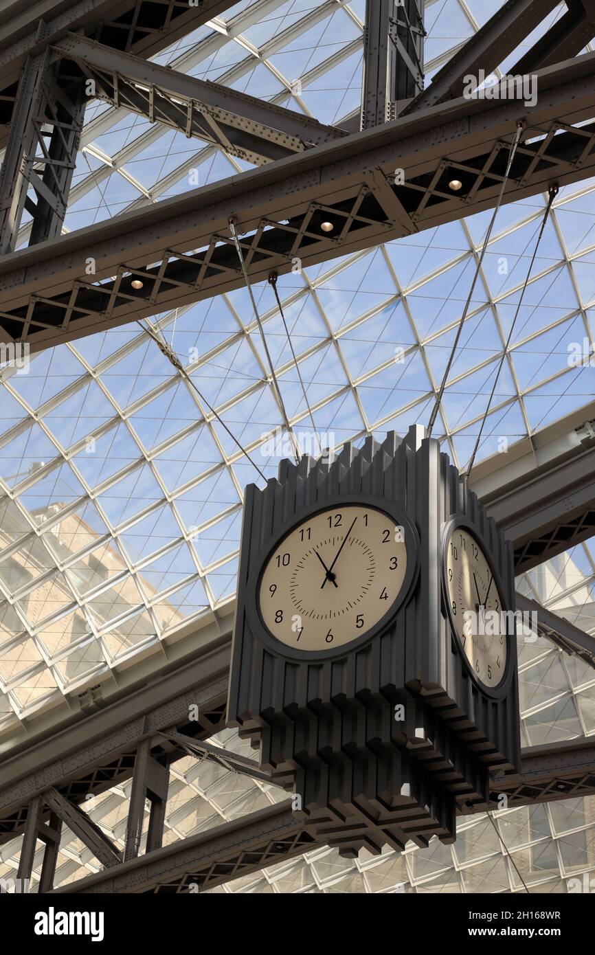 A passenger taking photo of head house clock under glass skylights in