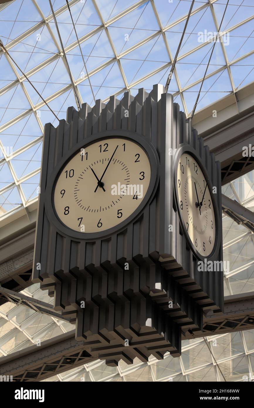 A passenger taking photo of head house clock under glass skylights in