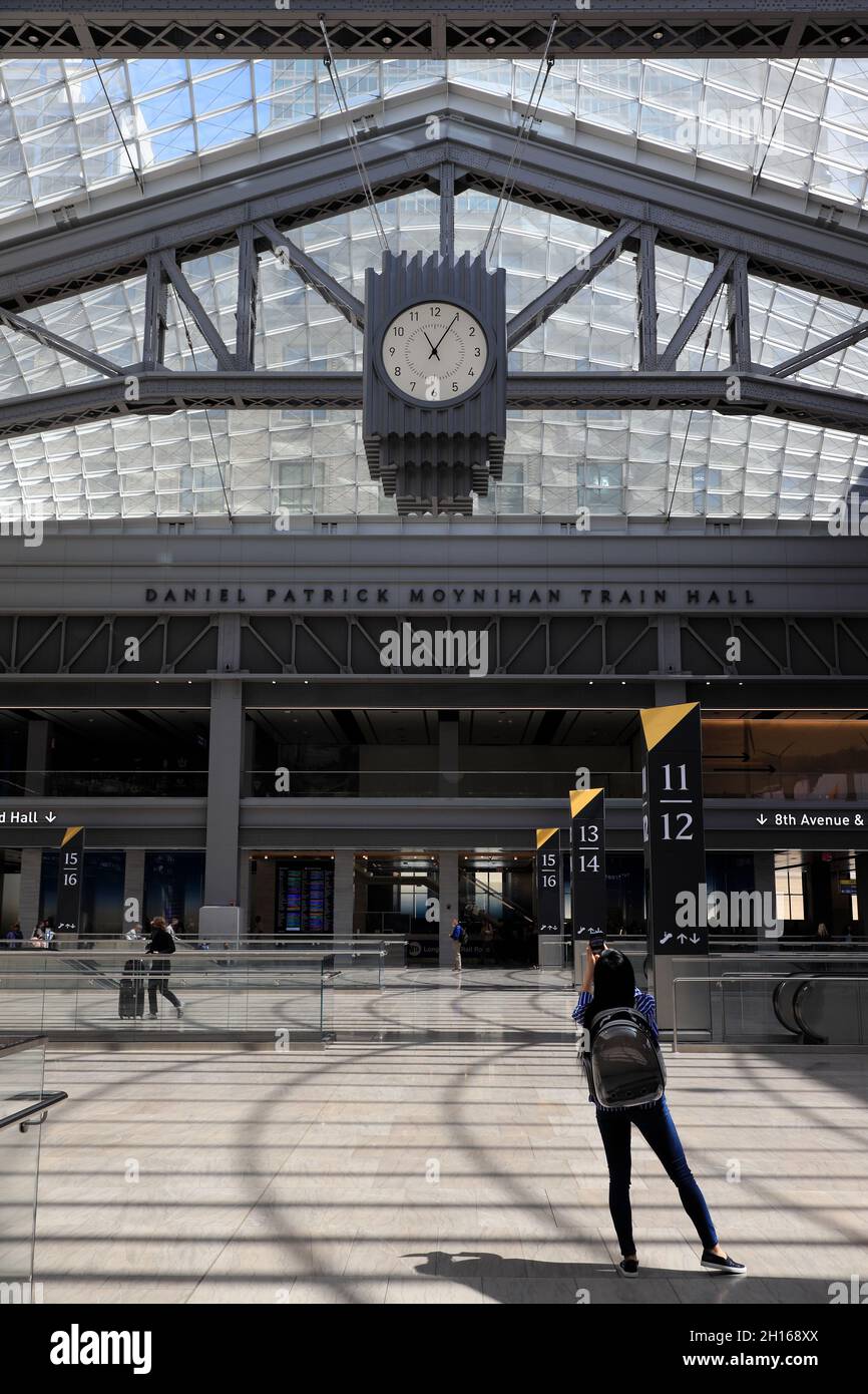 A passenger taking photo of head house clock under glass skylights in