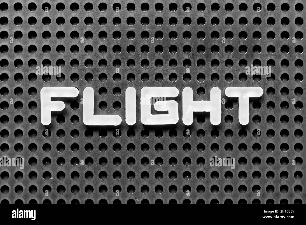 White alphabet letter in word flight on black pegboard background Stock Photo