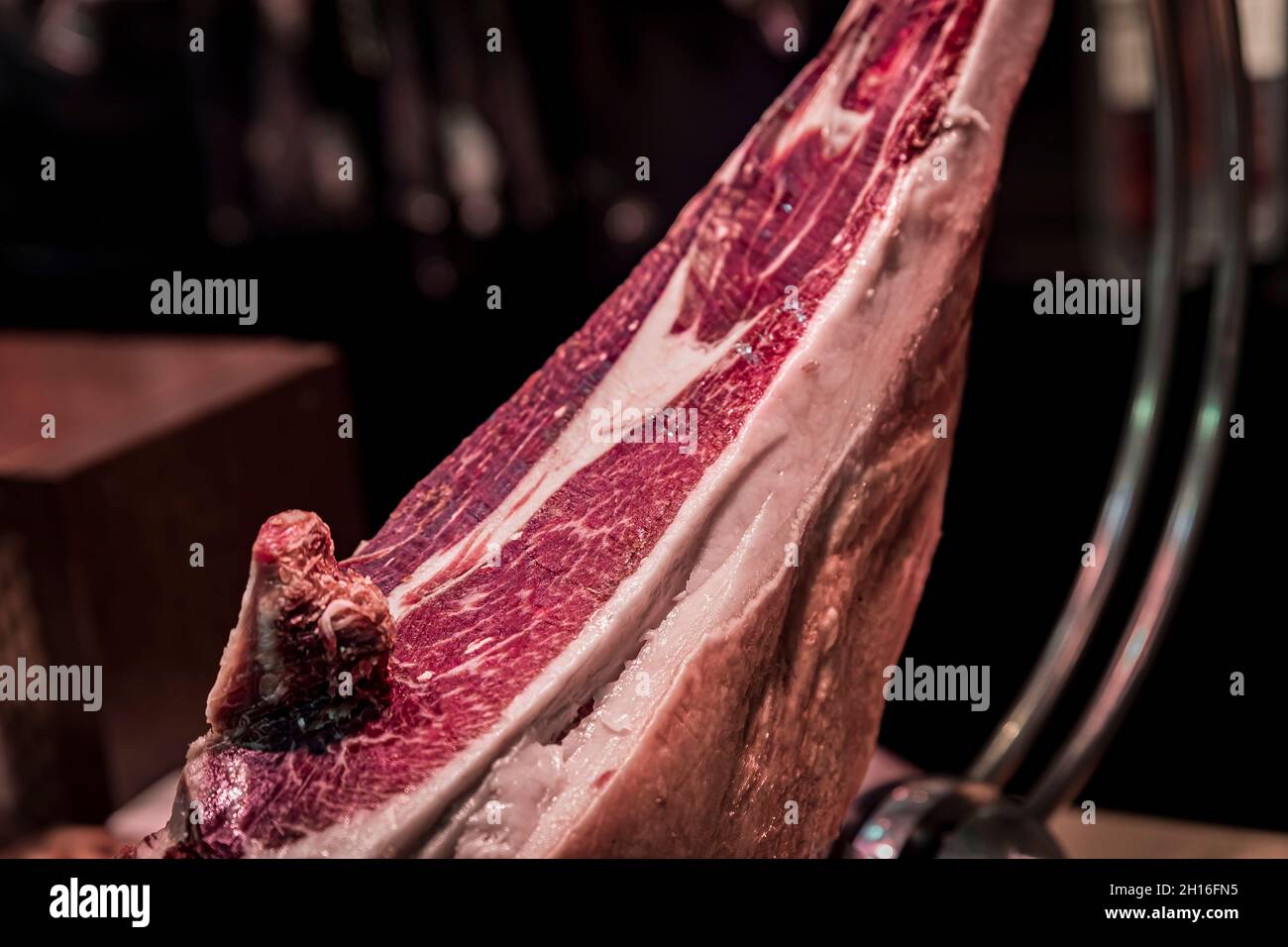 Whole bone-in leg of Spanish serrano iberico ham on a carving stand at a local butcher shop in the old town or Casco Viejo in Pamplona, Spain Stock Photo