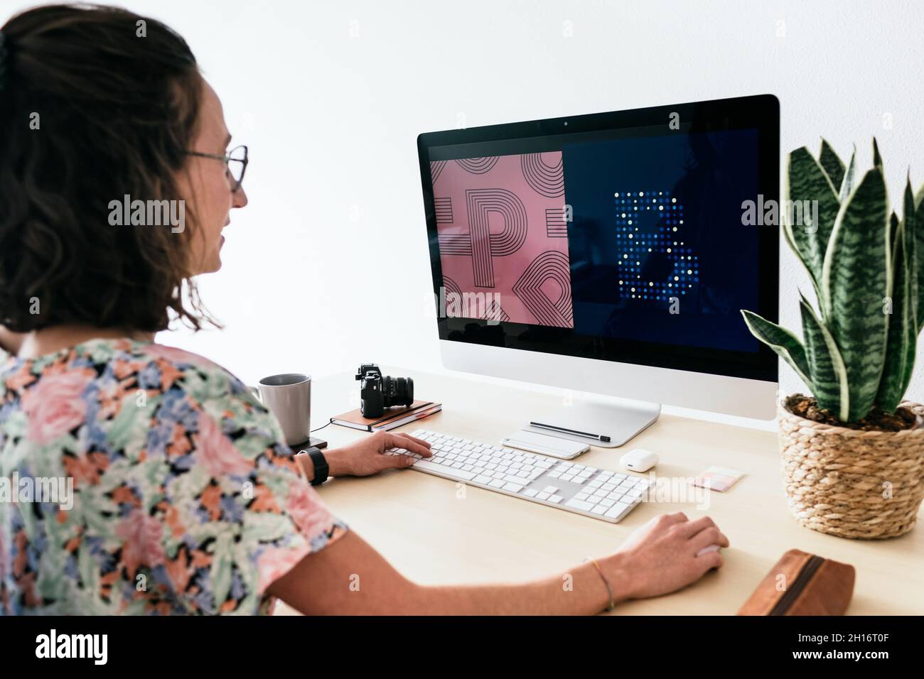From above of female designer using contemporary computer while working in modern office Stock Photo