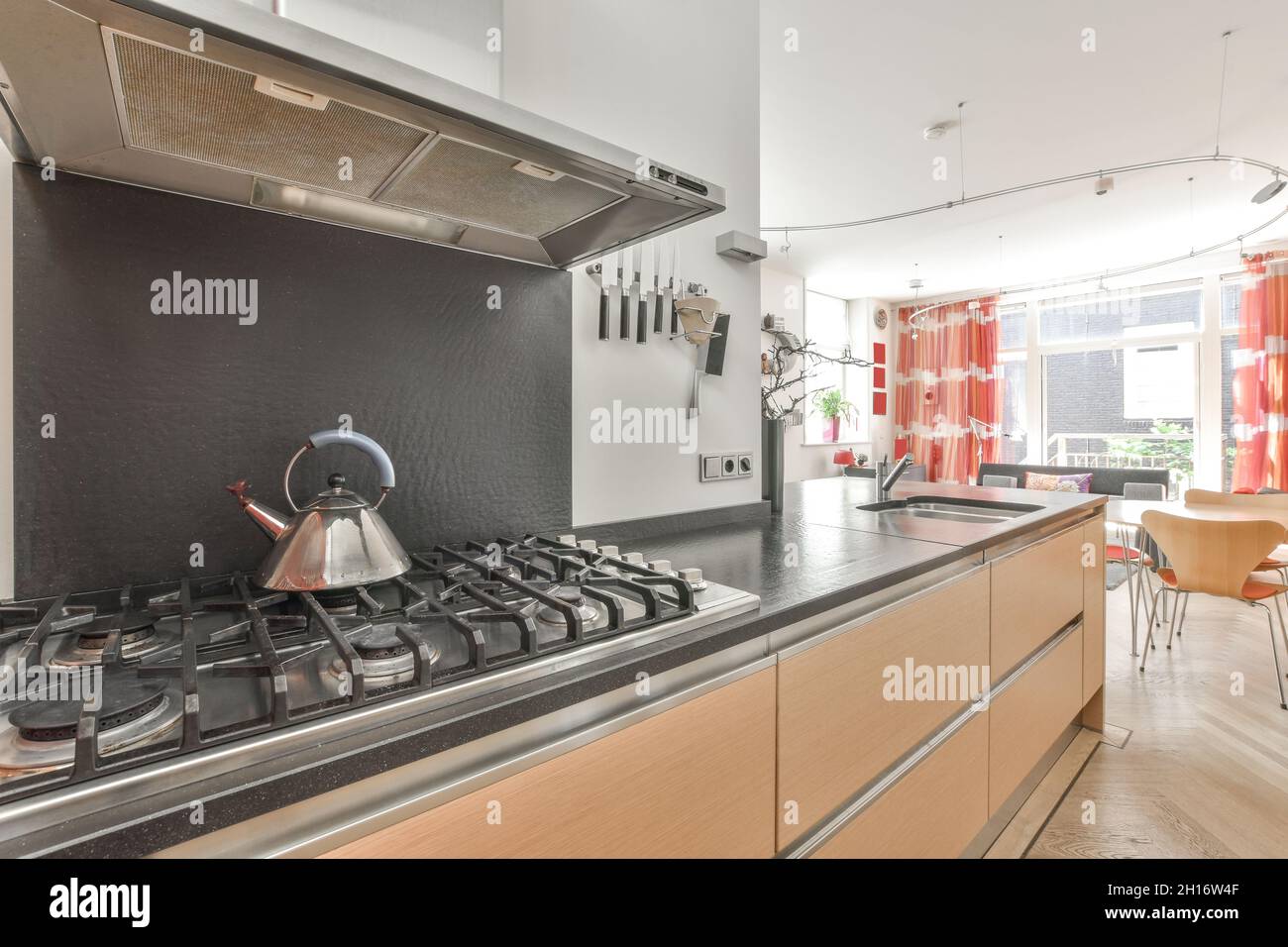 Metal kettle on gas cooker under extractor hood near kitchen