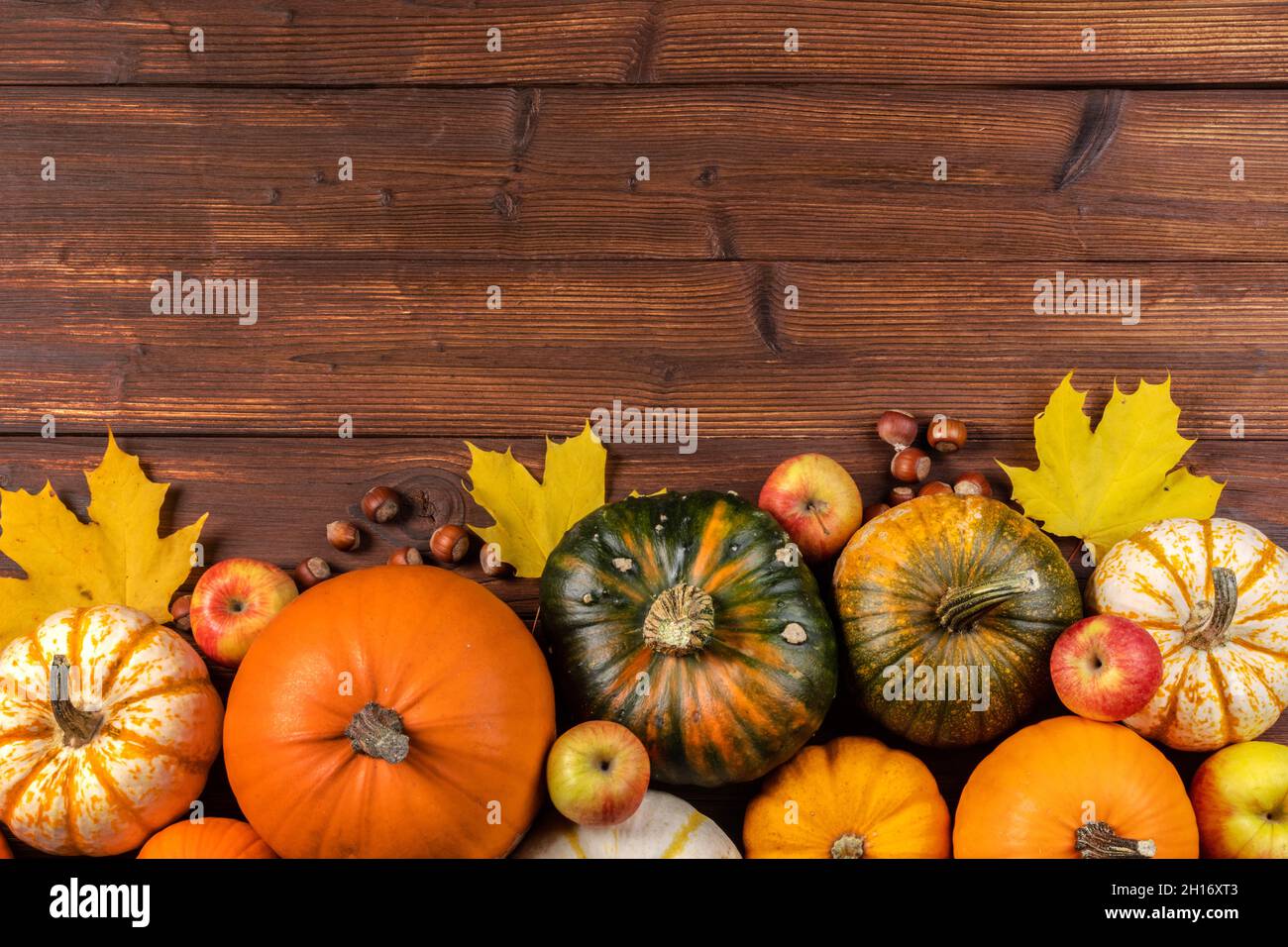 Fall border with pumpkins, leaves and apples. Top view on a rustic dark ...