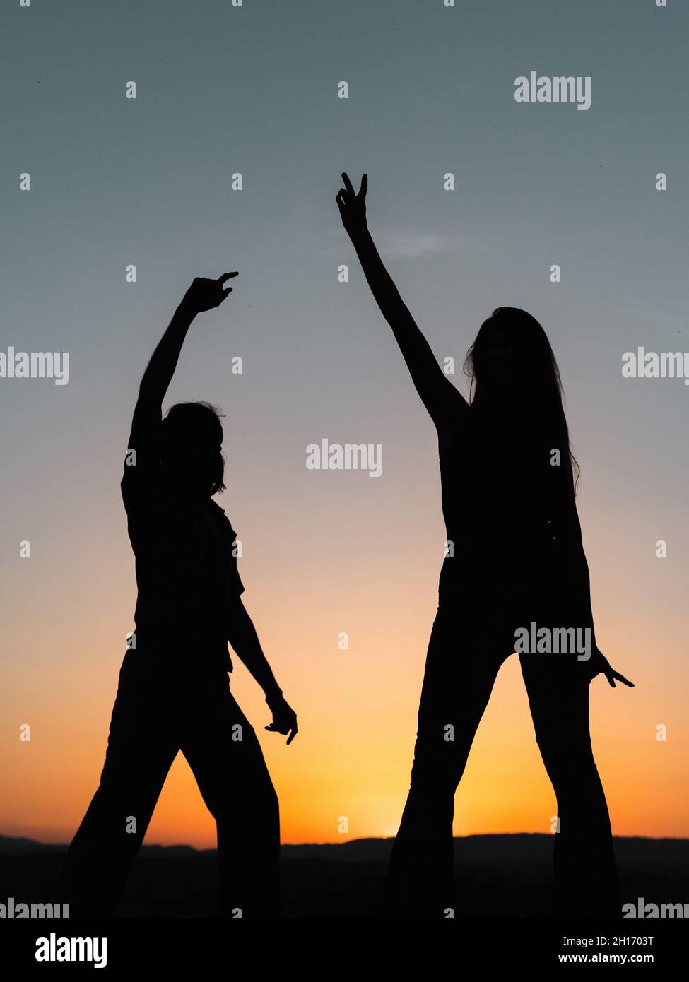 Silhouettes of a couple dancing in nature while the sun hides in the ...