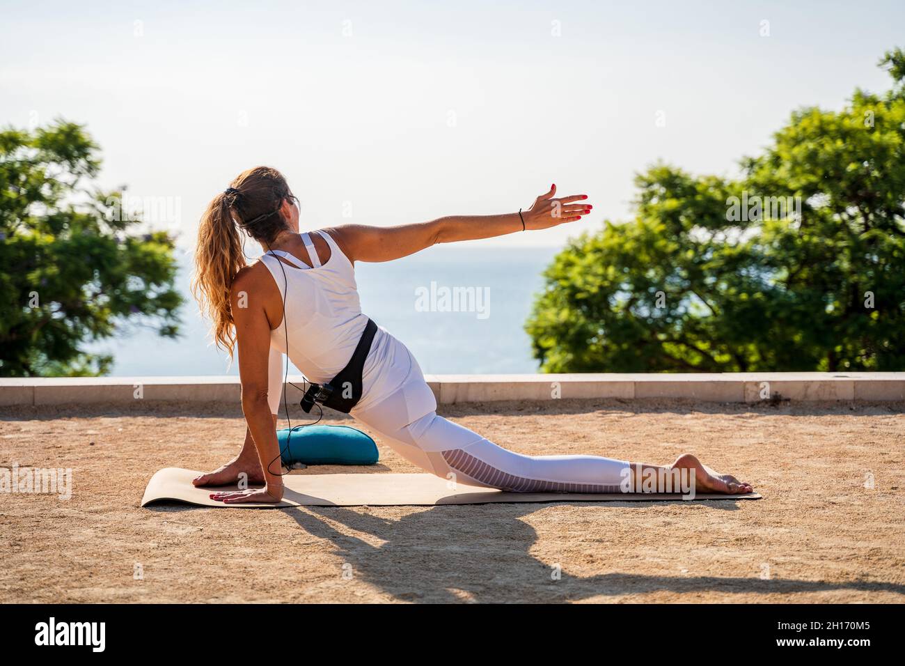 Back view of anonymous female instructor performing Horizon Lunge