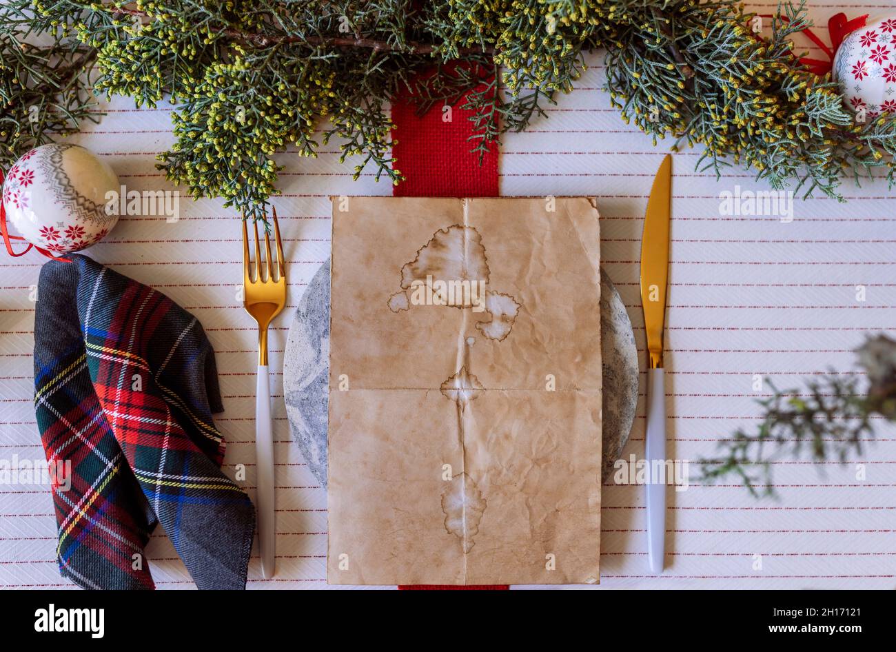 From above red holiday place setting with empty menu on white tablecloth Stock Photo