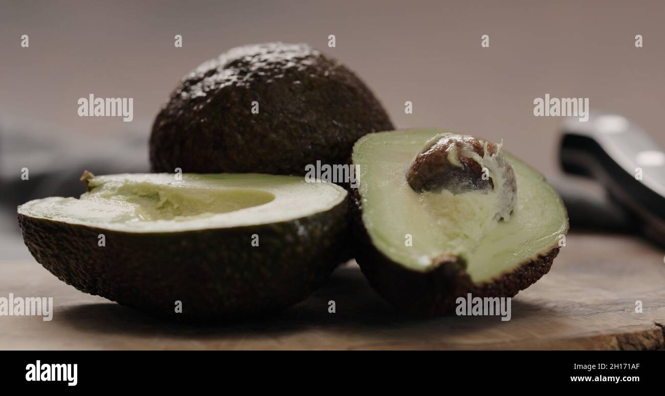 dark ripe avocado on olive board closeup, wide photo Stock Photo