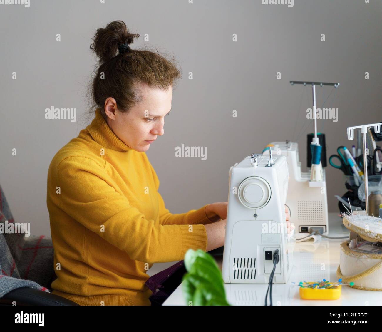 A girl is sewing on a machine. Mom shows how to work with equipment.  Close-up. Stock Photo by ©Alexeg84 314794668