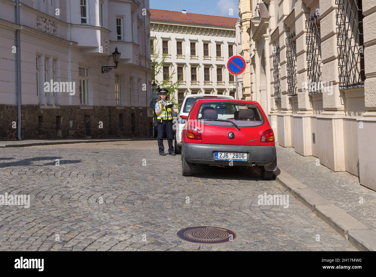 BRNO, CZECH REPUBLIC - APRIL 24, 2018: A policewoman issues a fine for incorrect parking on a city street Stock Photo