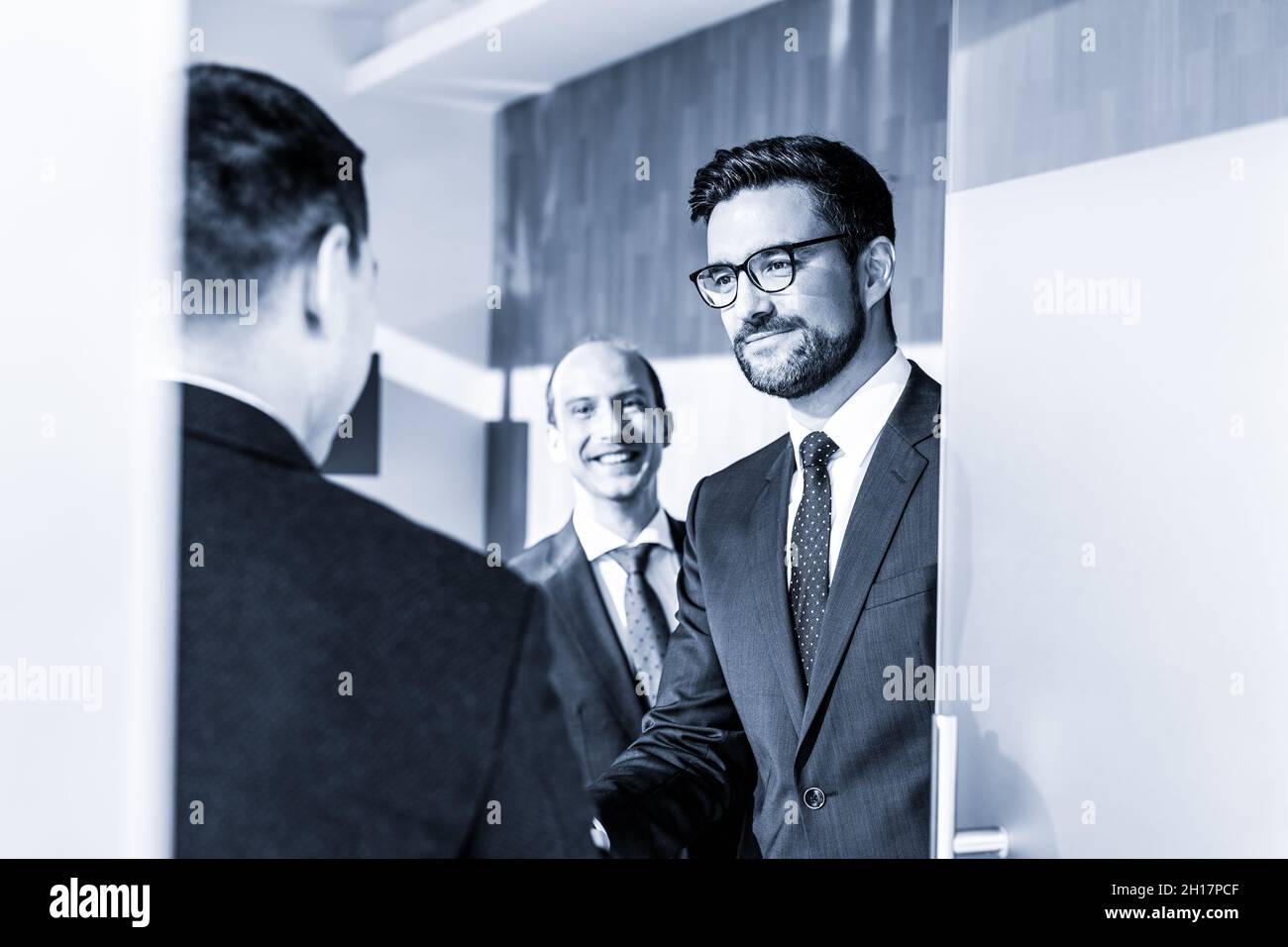 Group of confident business people greeting with a handshake at business meeting in modern office or closing the deal agreement by shaking hands. Stock Photo