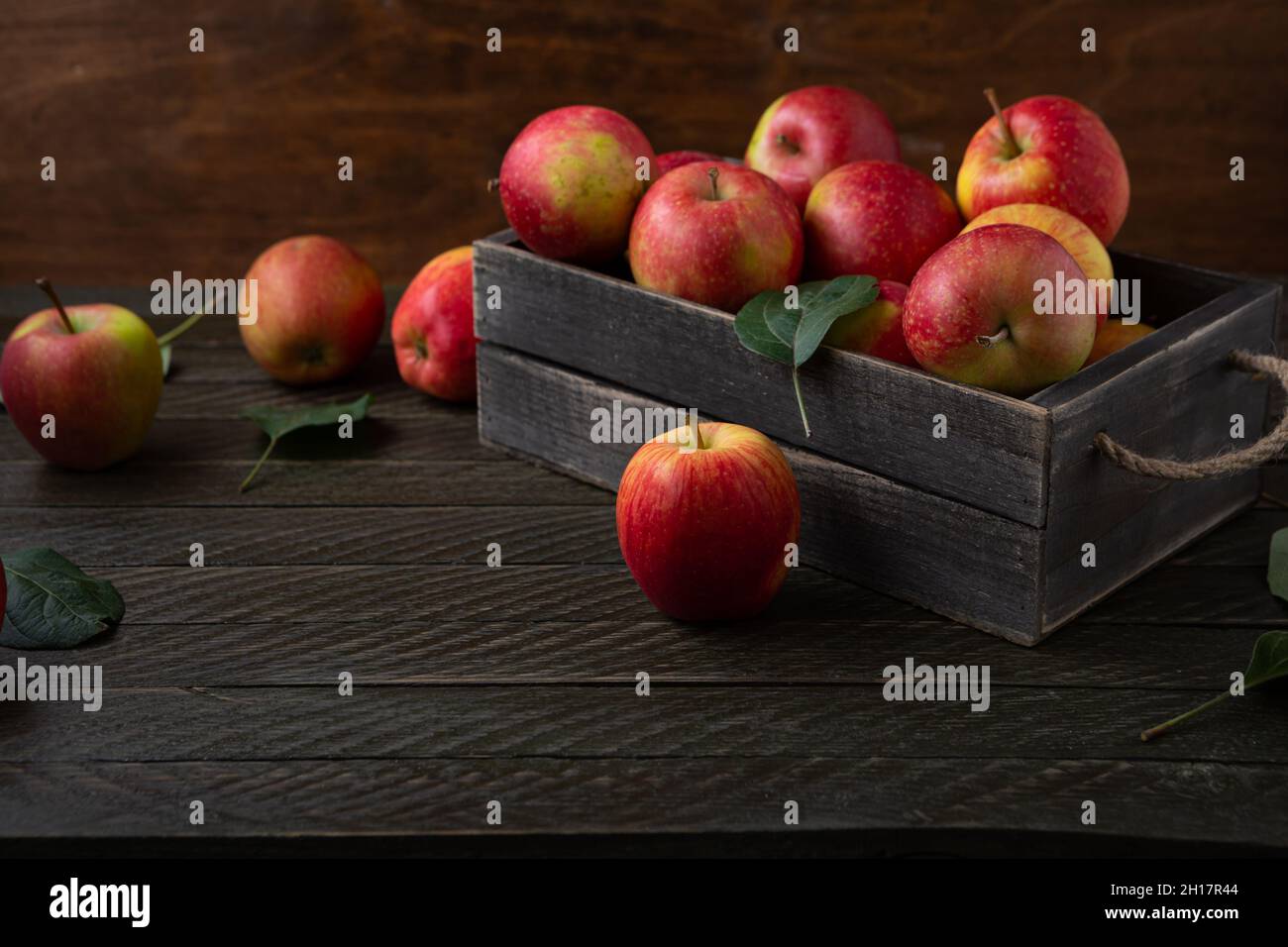 Apples in wooden crate harvest concept on wooden table Stock Photo